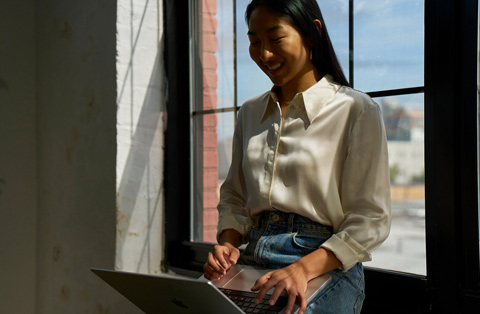 Apple Storen työntekijä seisoo asiakkaan vieressä, molemmat käyttävät MacBookia.