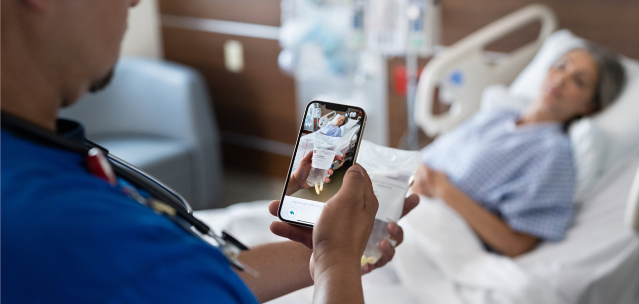 Eine Pflegekraft scannt die Medikamente einer Patientin.